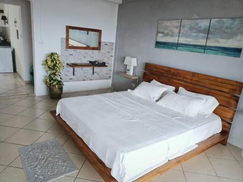 Ruisseau CréoleSurf house holidays的卧室配有一张白色大床和木制床头板