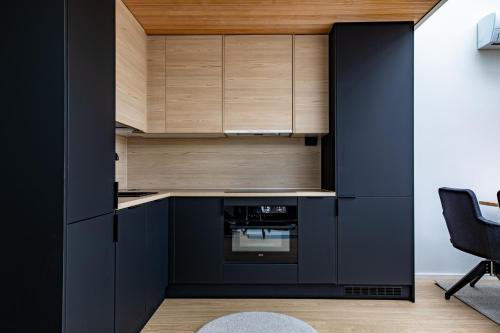 列维Levin Primus的厨房配有黑色橱柜和黑色烤箱