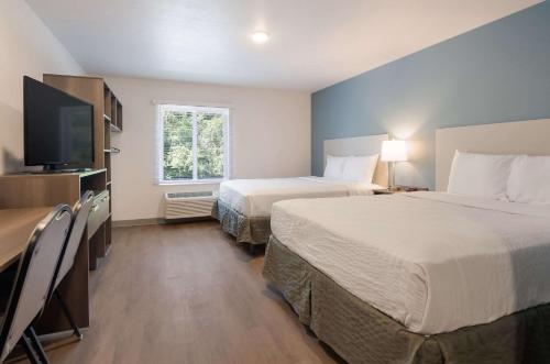 林奇堡WoodSpring Suites Lynchburg VA的酒店客房设有两张床和一台平面电视。