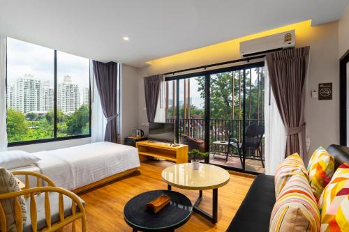 曼谷萨格布小巢酒店的客厅设有床和大窗户
