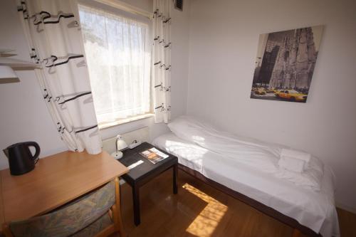 艾特韦Egtved Hotel的一间卧室配有一张床、一张书桌和一个窗户。