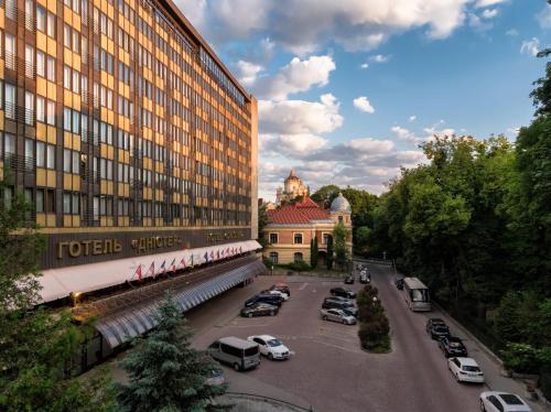 利沃夫达尼斯特尔尊贵酒店的停车场内停放汽车的大型建筑