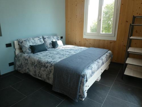阿斯蒂Ca' San Michele的一间卧室配有一张带蓝色棉被的床和窗户。