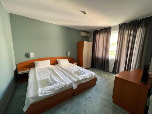 拉夫达Family Hotel Saga的一间卧室配有一张带白色床单的大床