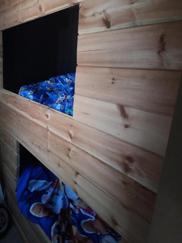 拉纳肯Vakantiehuisje的木墙客房的一张床位