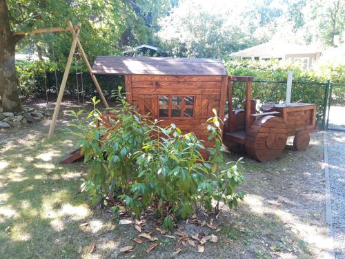 拉纳肯Vakantiehuisje的木车坐在树旁的院子中