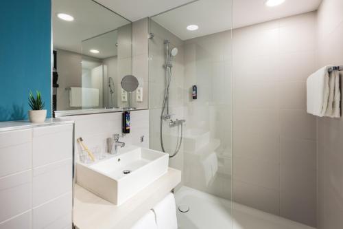 杜塞尔多夫the niu Seven的白色的浴室设有水槽和淋浴。