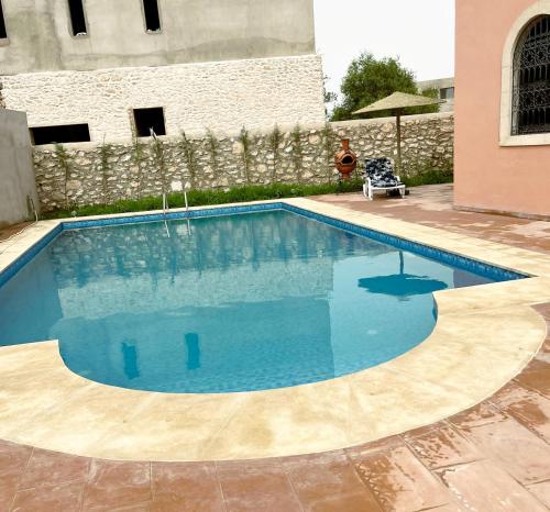 索维拉Riad Aïcha Addi - Poolside - Traditional Moroccan的庭院里的一个蓝色海水游泳池