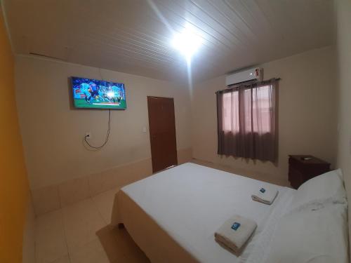 里约布兰科Apart Hotel M6D的卧室配有一张床,墙上配有电视。