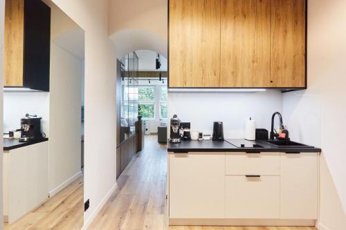 卡尔帕奇Apartament "Powoli" z darmowym parkingiem的厨房铺有木地板,配有白色橱柜。