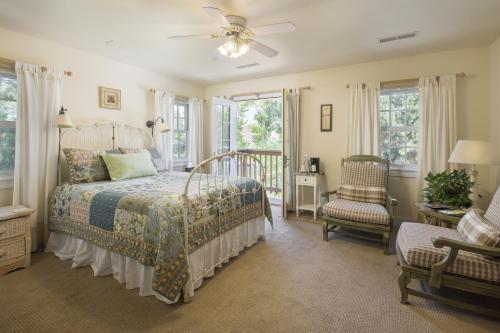 摩押Sunflower Hill Inn的一间卧室配有一张床、一把椅子和窗户。