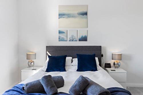 StokeinteignheadStunning Coastal Apartment in Maidencombe with Sea Views & Garden的一间卧室配有一张带蓝色枕头的大床