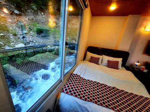 KārandūkaiBlue Water Resort Kalam的小房间设有窗户、一张床和一个窗口
