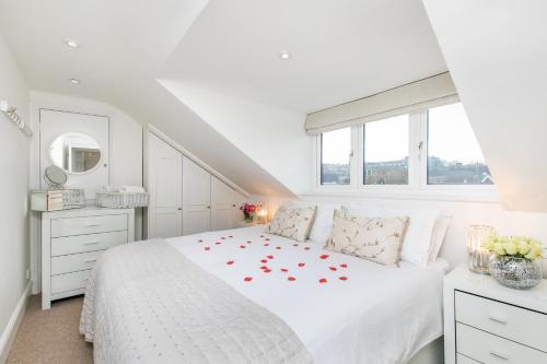 温彻斯特The Sky Penthouse的白色卧室,配有一张白色的红色玫瑰床