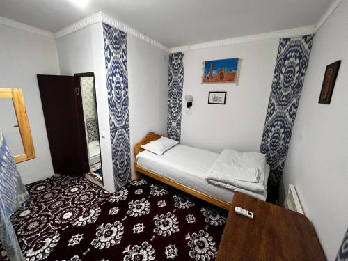希瓦Polvonnazir Guest House的小房间设有一张小床和一个窗户