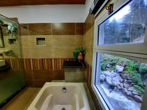 KārandūkaiBlue Water Resort Kalam的带浴缸的浴室和窗户。