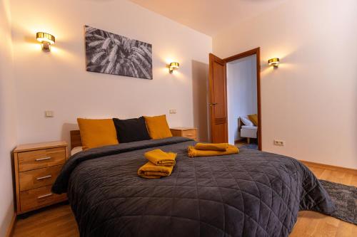 艾纳日Priedes māja的一间卧室配有一张大床和黄色枕头