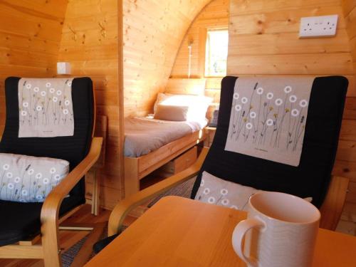 奥马Cosy Pod-Cabin near beautiful landscape in Omagh的小房间设有一张床、一张桌子和椅子