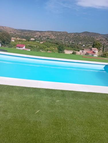 卡兰达Cabezo Buñuel Hostal的一座拥有蓝色海水和绿色草地的大型游泳池