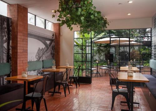 利马Lima 18 Boutique的餐厅设有桌椅和大窗户。