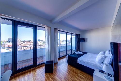 布加勒斯特萨洛里亚酒店的一间卧室设有一张床和大窗户