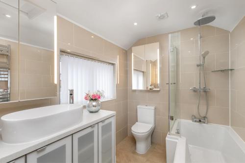 温彻斯特The Nestle House的浴室配有白色浴缸、卫生间和水槽。