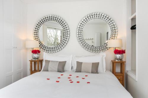 温彻斯特The Nestle House的卧室在红色玫瑰床上方设有两面镜子