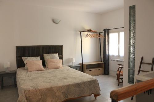 马赛Maisonnette OCELIA 2 personnes Port de la Madrague的一间卧室配有一张床、一张桌子和一个窗户。