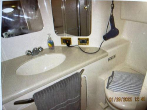 帕诺滩Delightful 2 Bdrm Sport Yacht with Pool的一间带水槽、镜子和卫生间的浴室