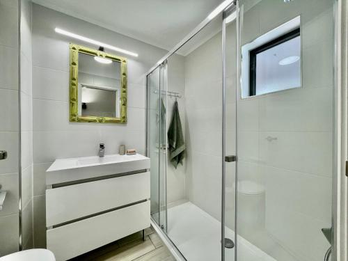 维拉摩拉The Olive Tree Vilamoura Centre的带淋浴、盥洗盆和镜子的浴室