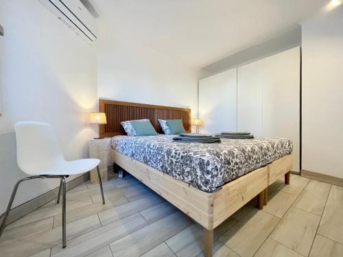 维拉摩拉The Olive Tree Vilamoura Centre的一间卧室配有一张床和一张白色椅子