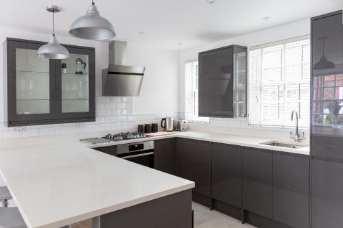 伊顿Hampden Apartments - The Louis的厨房配有黑色橱柜和白色台面