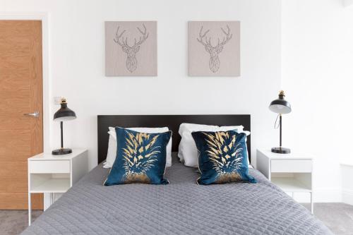 伊顿Hampden Apartments - The Louis的一间卧室配有带蓝色和金色枕头的床