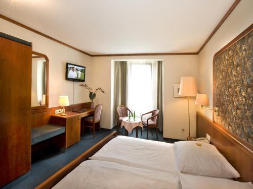 埃斯林根斯策尔特酒店的配有一张床和一张书桌的酒店客房