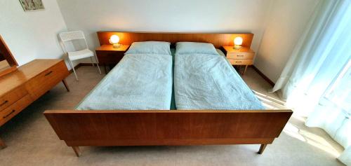 纳图尔诺Zweizimmer-Wohnung mit Parkgarage的一间卧室设有两张床和两张台灯。