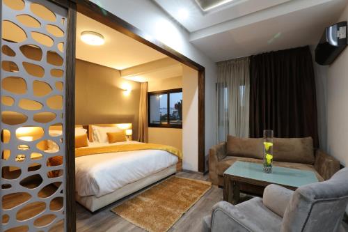 卡萨布兰卡Silver Suites Hotel & Spa的一间卧室配有一张床、一张沙发和一张桌子