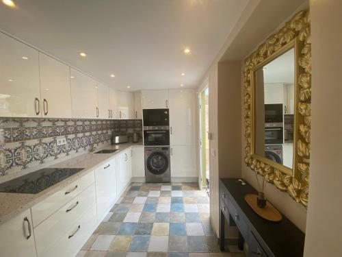 阿德耶Luxury two-bedroom apartment Four Seasons的厨房配有白色橱柜和瓷砖地板。