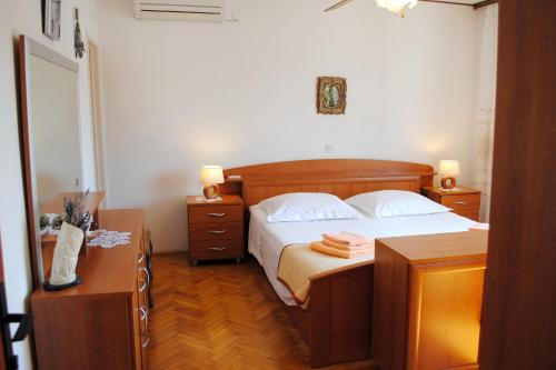 米欧纳Apartments by the sea Milna, Brac - 733的一间卧室配有一张带2个床头柜和2张桌子的床