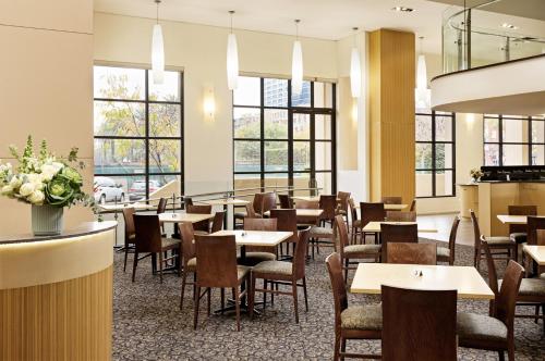 墨尔本View Melbourne的餐厅设有桌椅和窗户。