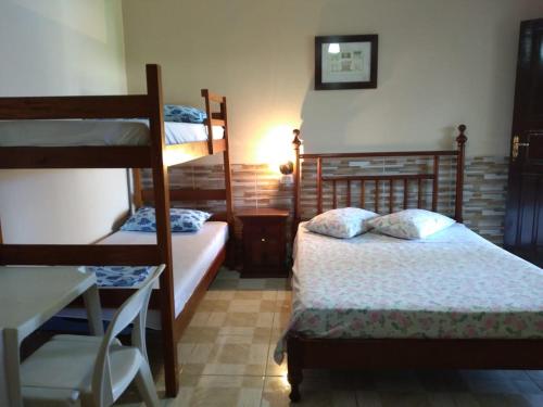 伯迪亚哥Pousada da Geisa的一间卧室配有两张双层床和一张书桌