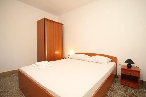拉斯托伏Double Room Lucica 990a的卧室配有白色的床和木制橱柜。