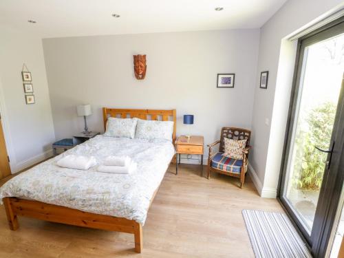 DunmoreThe Visiting House的一间卧室设有一张大床和一个窗户。