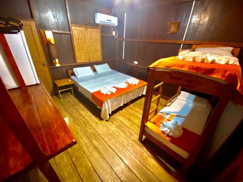 IrandubaAmazonia Jungle Hotel的客房设有两张床和一张双层床。