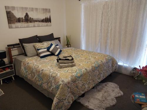 卡尔古利2BR luxury house in Piccadilly的一间卧室配有一张带毯子的床和窗户