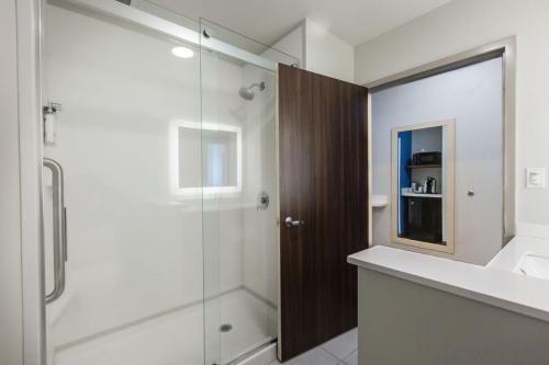 圣艾伯特Holiday Inn Express & Suites Edmonton N - St Albert, an IHG Hotel的带淋浴和玻璃淋浴间的浴室(位于后门)