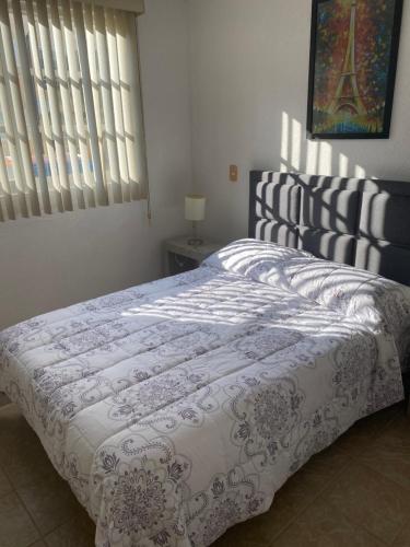 阿卡普尔科Renta de departamento en Acapulco Diamante的一间卧室配有一张床和被子