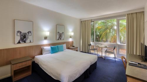 天鹅山天鹅山度假酒店的酒店客房设有床、桌子和窗户。