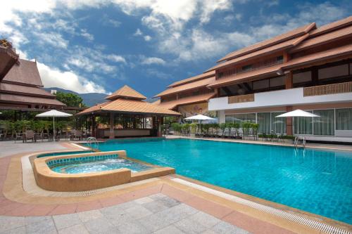 清迈Khum Phucome Hotel -SHA Extra Plus的大楼前的大型游泳池