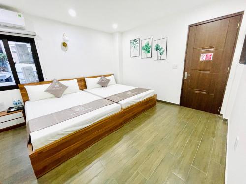 吉婆岛Little Vietnam Hotel - Cát Bà的一间卧室设有一张大床,铺有木地板