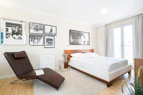 特拉弗明德Haus Traavmünn的白色卧室配有床和椅子